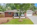 Charming brick home with a cozy front porch, blue accents, and a well-manicured lawn at 3880 Admiral Dr, Chamblee, GA 30341