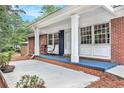 Charming covered front porch with brick columns, ample seating, and brick accents at 3880 Admiral Dr, Chamblee, GA 30341