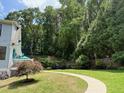 Spacious backyard featuring a well-maintained lawn, mature trees, and lush greenery at 158 Delano Dr, Decatur, GA 30032