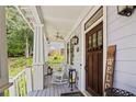 Inviting front porch featuring rocking chairs, decorative columns, and a view of the landscaped yard at 1589 Delano Dr, Decatur, GA 30032