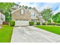 Beautiful two-story home showcasing a spacious driveway, brick and siding exterior, and well-kept landscaping at 3060 Mccannon Mill Dr, Dacula, GA 30019