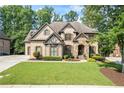 Beautiful brick home featuring manicured lawn and a stone-accented entrance at 2517 Stone Manor Dr, Buford, GA 30519