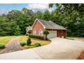 Side view of a brick home, revealing a two-car garage and a well-maintained lawn at 3648 Clark Hill Way, Buford, GA 30519