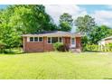 Traditional brick home with a lush green lawn and mature trees in a serene setting at 1167 Sanders Dr, Morrow, GA 30260