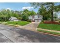 Well-manicured lawn leads to a charming two-story home with a two-car garage at 12290 Greenmont Walk, Alpharetta, GA 30009