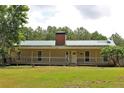 Charming single-story home with a metal roof and a cozy front porch and large front yard at 3129 Etchison Rd, Loganville, GA 30052