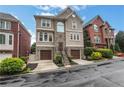 Elegant home exterior with stone accents, double garage doors, and manicured landscaping at 13 Highland Park Ne Ln, Atlanta, GA 30306