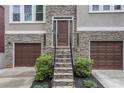 Inviting front entrance with stone steps, wrought iron railings, and double garage doors at 13 Highland Park Ne Ln, Atlanta, GA 30306