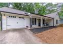 A charming home with a two-car garage, manicured landscaping, rocking chairs, and black shutters at 2038 Summertown Dr, Norcross, GA 30071