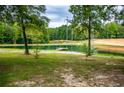 A view of one of the several ponds on the property with mature trees surrounding at 300 Old Boy Scout Rd, Whitesburg, GA 30185