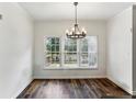 Bright dining room with wood floors, a modern chandelier, and a large window view at 630 Dana Pointe Ct, Lawrenceville, GA 30045
