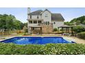 Backyard with a large inground pool, surrounding patio, gazebo and lush landscaping at 630 Dana Pointe Ct, Lawrenceville, GA 30045