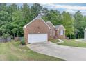 Inviting brick home with a two-car garage and a spacious driveway with lush lawn at 1258 Rocky Branch Trl, Lawrenceville, GA 30043