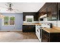 Vintage kitchen featuring dark cabinetry, butcher block countertops, and white appliances. Natural light fills the space at 129 Bill Smith Dr, Canton, GA 30114