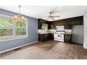Kitchen featuring dark wood cabinets, light countertops, and modern appliances with a view to the outdoors at 129 Bill Smith Dr, Canton, GA 30114