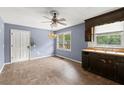 Kitchen area with white trim door, original dark cabinets, and natural light, offering a cozy space at 129 Bill Smith Dr, Canton, GA 30114