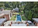 Beautiful backyard with long pool, stone patio, and landscaped lawn at 2883 Andrews Nw Dr, Atlanta, GA 30305