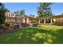 Picturesque backyard featuring lush lawn, manicured garden beds, and colonnade at 2883 Andrews Nw Dr, Atlanta, GA 30305