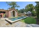 Backyard pool with stone patio, landscaped yard, and pool house at 2883 Andrews Nw Dr, Atlanta, GA 30305