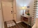 Well-lit foyer features hardwood floors, neutral walls, stylish console table with decor, and front door at 3915 Woodridge Way, Tucker, GA 30084