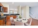 Eat-in kitchen with warm wood cabinets, granite countertops, stainless appliances, and a nearby staircase at 931 Society Cir, Atlanta, GA 30331