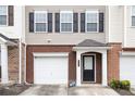 Close-up of the townhome showing the brick accents, single-car garage, and covered front entrance at 931 Society Cir, Atlanta, GA 30331