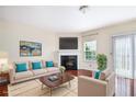 Bright living room with hardwood floors, fireplace, recessed lighting, and large windows for natural light at 931 Society Cir, Atlanta, GA 30331