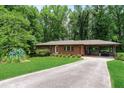 Inviting home with a long driveway, lush green lawn, and a covered porch perfect for relaxing outdoors at 1630 Park Ln, Marietta, GA 30066