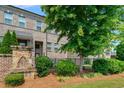 Charming exterior of a townhouse with a stone pillar and mature landscaping in a well manicured yard at 1463 Edgebrook Ne Ct # 14, Atlanta, GA 30329