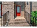 Close up of a brick townhouse with a bright red front door and iron handrails leading up to it at 1463 Edgebrook Ne Ct # 14, Atlanta, GA 30329