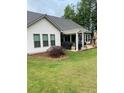 Beautiful backyard with a stone patio, black grill, green grass and wooden fence at 203 Belmont Park Dr, Canton, GA 30115