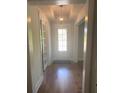Inviting foyer with hardwood floors, a decorative light fixture, and a front door with a window at 203 Belmont Park Dr, Canton, GA 30115