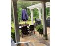 Covered patio with a dining table, outdoor seating, and green foliage at 203 Belmont Park Dr, Canton, GA 30115