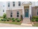 Inviting townhouse entrance with a wreath-adorned front door and charming brick detailing at 361 Watson Ave, Woodstock, GA 30189