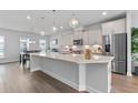 Modern kitchen features a large island with pendant lighting, stainless steel appliances, and hardwood flooring at 361 Watson Ave, Woodstock, GA 30189