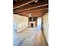 A living room showing the exposed ceiling, hardwood flooring, and a non-decorative fireplace at 1386 Bluefield Sw Dr, Atlanta, GA 30310