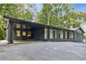 A dark blue and white home with a covered parking area with asphalt driveway at 6878 Brandon Mill Rd, Sandy Springs, GA 30328