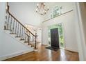 Bright foyer featuring hardwood floors, staircase, chandelier, and elegant front door at 265 Landfall Rd, Atlanta, GA 30328