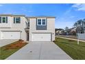 View of a new construction townhome with attached garage and large driveway at 349 Heavenly Hollow Pl, Mcdonough, GA 30253