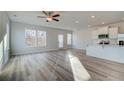Open-concept living room featuring light wood-look floors, lots of windows and access to the kitchen at 349 Heavenly Hollow Pl, Mcdonough, GA 30253