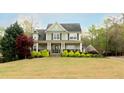 Beautiful two-story home with a green lawn and mature trees, offering a serene setting at 109 Lighthorse Blvd, Mcdonough, GA 30252
