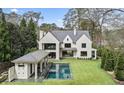A spacious backyard featuring a refreshing pool, pool house, and expansive green lawn at 258 Pineland Nw Rd, Atlanta, GA 30342