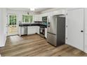 Modern kitchen featuring stainless steel appliances, white cabinets and door to the backyard at 2201 Logan Dr, Jonesboro, GA 30236