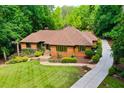 A beautifully landscaped home with a stone walkway and lush green lawn showcasing its elegant exterior at 1385 Northcliff Trce, Roswell, GA 30076