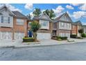Charming brick townhomes with two-car garages, landscaped front yards, and inviting curb appeal at 5207 Merrimont Dr, Alpharetta, GA 30022
