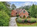 Elegant brick home surrounded by lush greenery and a winding driveway at 119 Kennemer Ct, Duluth, GA 30097