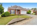 Well-maintained brick home features a manicured lawn and an attached garage with a concrete driveway at 2260 Burlington Ln, Snellville, GA 30078