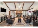 Spacious living room with vaulted ceilings, wood beams, stone fireplace, and cozy seating at 2969 White Ne Rd, Conyers, GA 30012
