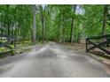 Gravel driveway winding through a tranquil, wooded landscape at 326 Seldom Seen Trl, Canton, GA 30115