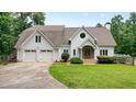 Charming home with a well-manicured lawn, a two-car garage, and an inviting entrance with stone accents at 326 Seldom Seen Trl, Canton, GA 30115